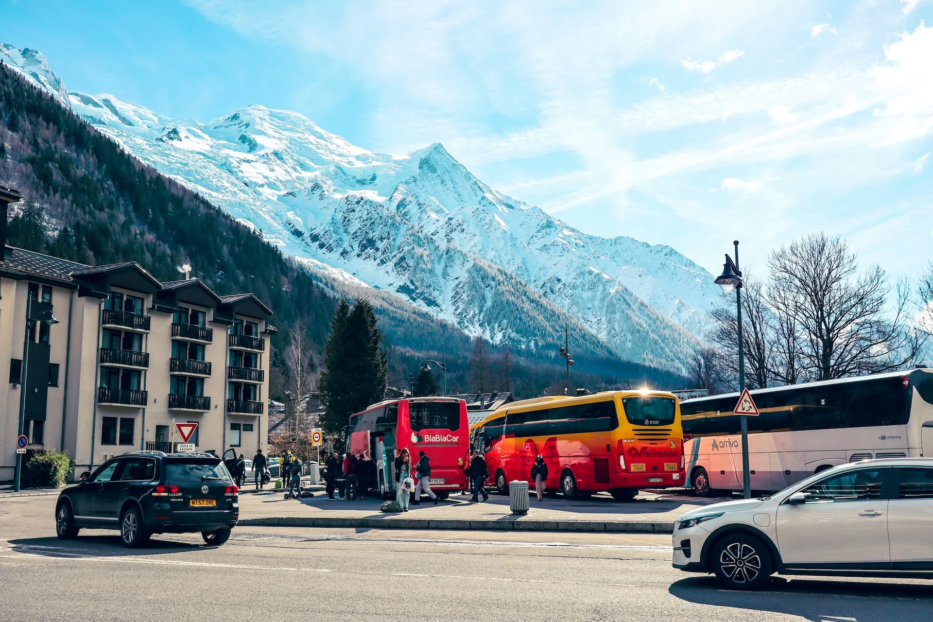 a group of buses parked next to each other in front of a mountain