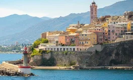 Bastia Airport with Corsican coastline, turquoise beaches, mountain peaks, luxury transfer vehicles, Mediterranean island paradise backdrop, premium airport transportation service