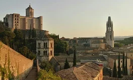 Girona Airport with Costa Brava coastline, medieval architecture, Mediterranean beaches, luxury transfer vehicles, Catalan culture backdrop, premium airport transportation service