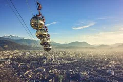 Grenoble Airport in French Alps with snow-capped mountains, luxury ski transfer vehicles, traditional French alpine villages, premium ski resort transportation service