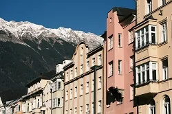 Innsbruck Airport in Austrian Alps with snow-capped Tyrolean mountains, luxury ski transfer vehicles, traditional Austrian alpine architecture, premium ski resort transportation service