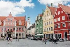 Memmingen Airport with Allgäu Alps landscape, modern terminal, luxury transfer vehicles, Bavarian countryside backdrop, premium airport transportation service