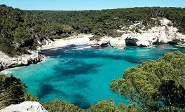 Menorca Airport with pristine Mediterranean beaches, white villages, turquoise waters, UNESCO Biosphere Reserve, luxury transfer vehicles, peaceful island backdrop, premium airport transportation service