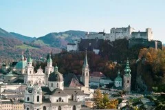Salzburg Airport with Mozart's city skyline, baroque architecture, Hohensalzburg Fortress, luxury transfer vehicles, Austrian Alps backdrop, premium airport transportation service