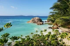 Seychelles pristine beaches with iconic granite boulders, turquoise waters, palm trees, luxury resorts, tropical rainforest, giant tortoises, coral reefs, traditional island boats