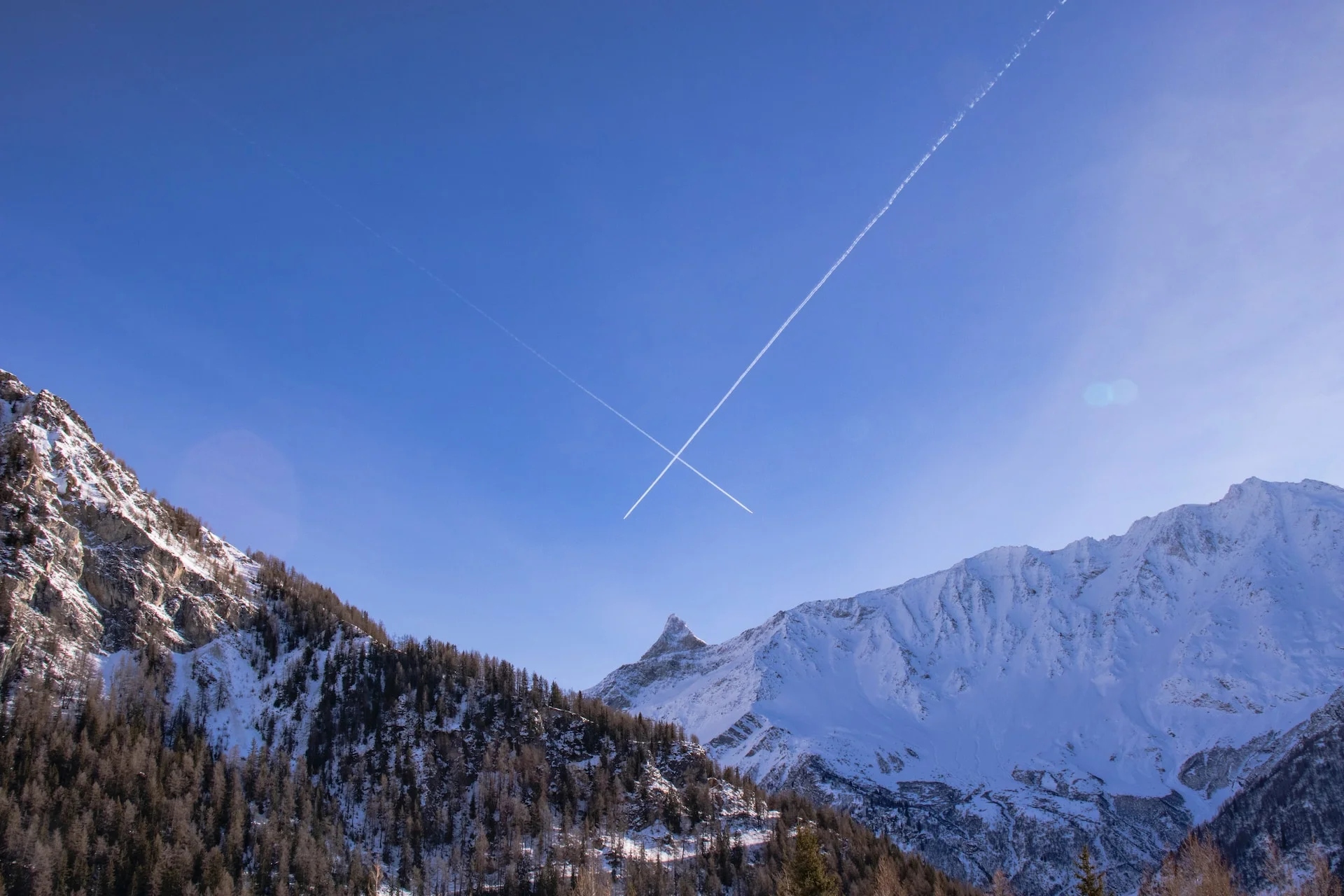 a plane is flying over a snowy mountain range